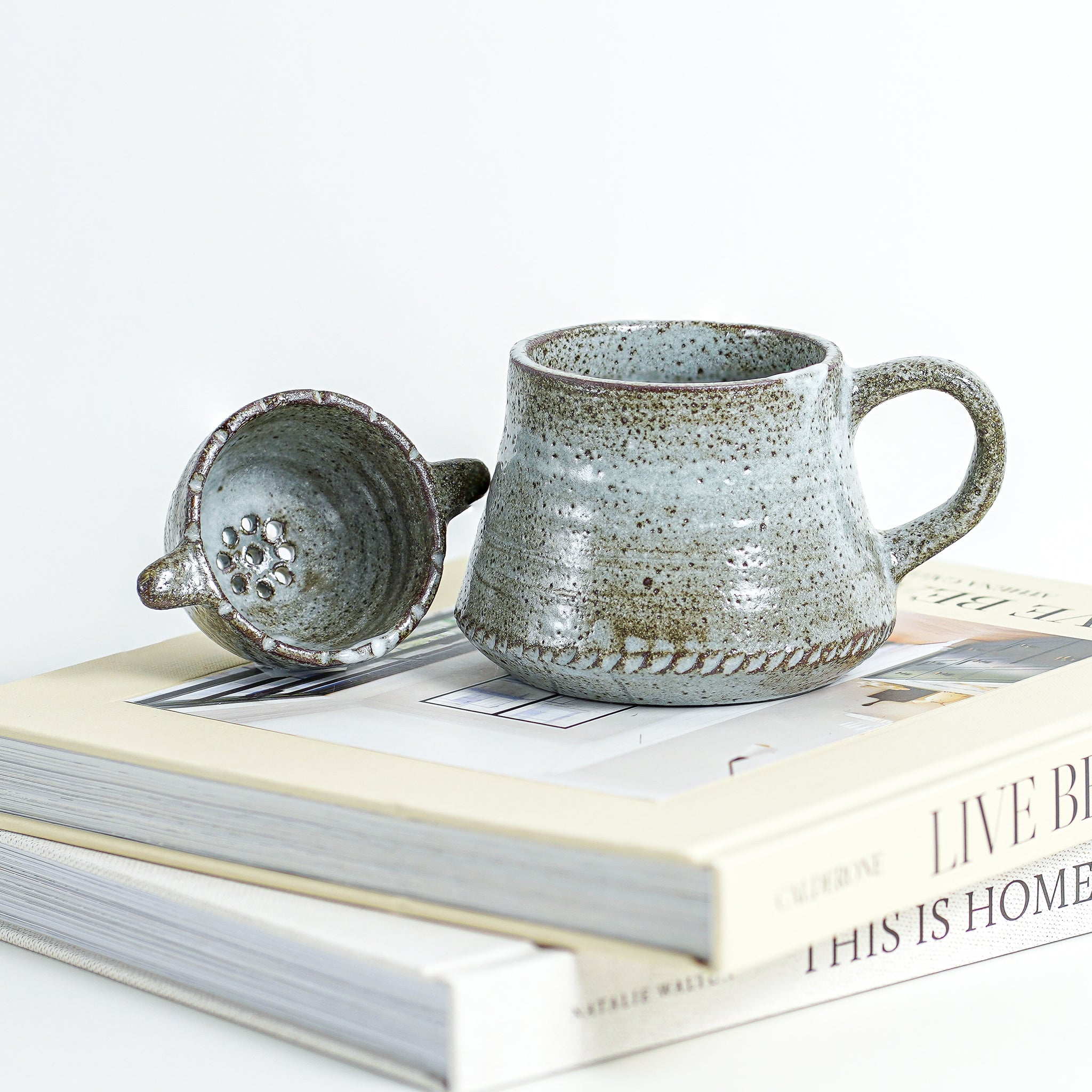 This ceramic mug set features a glossy, slightly-textured exterior and is an ideal present for yourself or someone you care about. It includes a convenient strainer for preparing loose-leaf tea blends for your morning or afternoon cup.