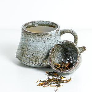This ceramic mug set features a glossy, slightly-textured exterior and is an ideal present for yourself or someone you care about. It includes a convenient strainer for preparing loose-leaf tea blends for your morning or afternoon cup.