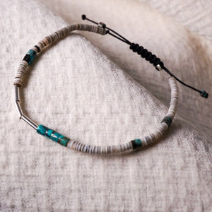 Garden of Desire - Embrace Bracelet. This adjustable braided drawstring bracelet features handcrafted 92.5 sterling silver tubes, together with Shell and Turquoise, a stone of protection and purification, and particularly highly valued by the Tibetans, Persians and Native Americans, turquoise is believed to have powers of divination, detoxification and cleansing.
